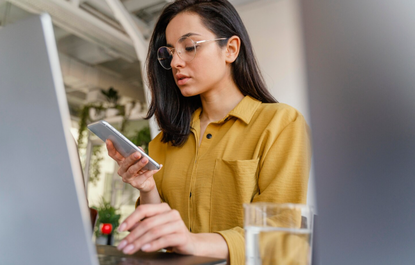 A woman checking a smartphone while working, illustrating searching versus knowing.